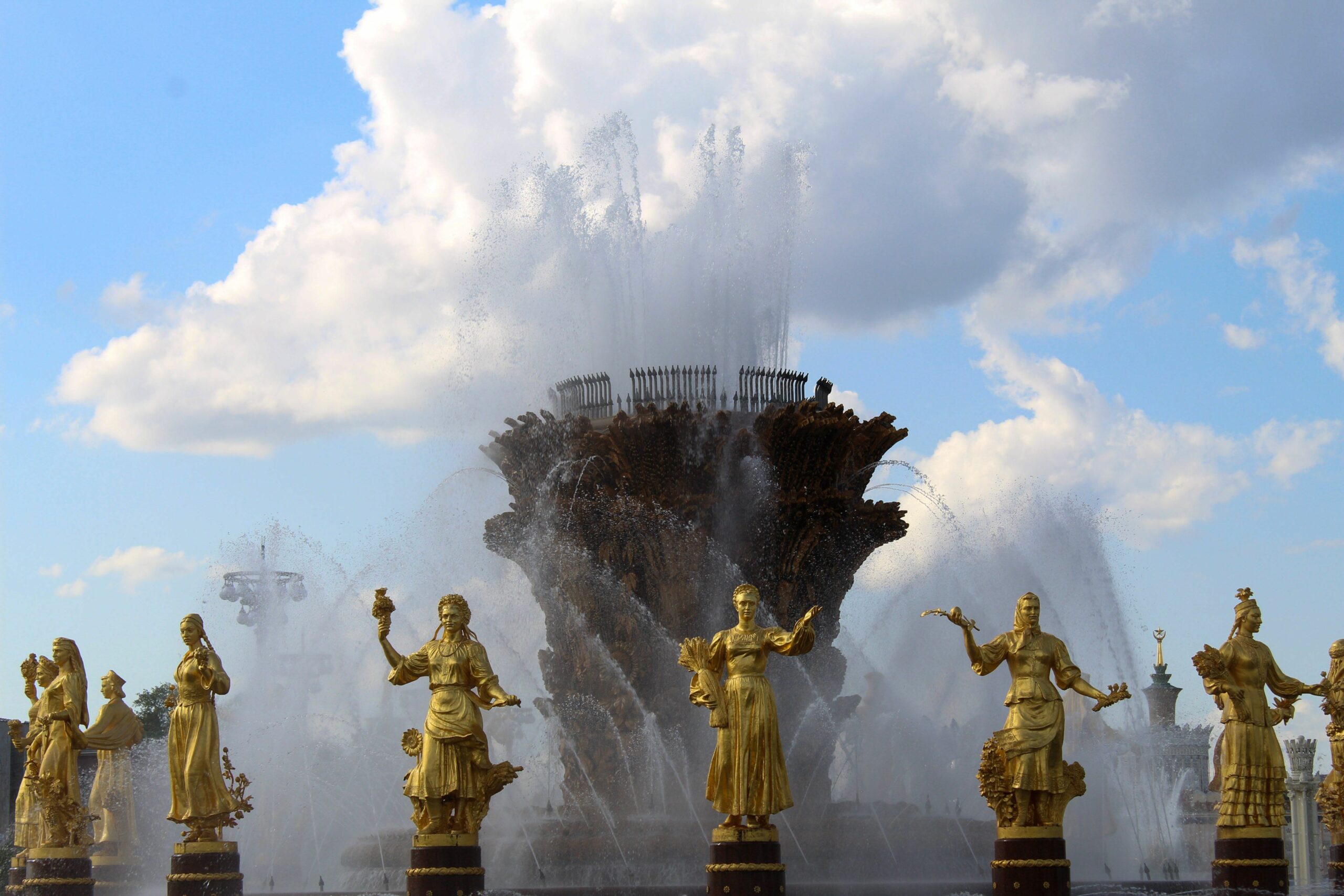 Stunning fountain with golden statues under a blue sky at VDNKh, showcasing artistic craftsmanship.