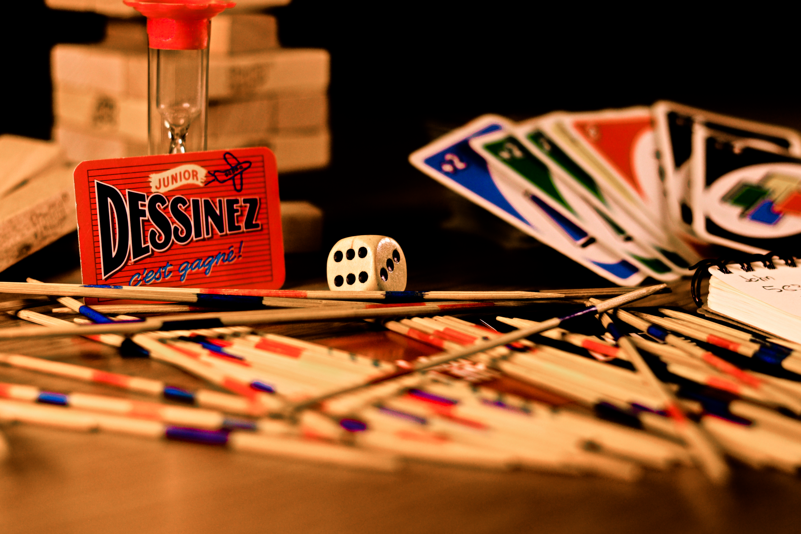 A vibrant arrangement of games, including cards, dice, and sticks, on a table.