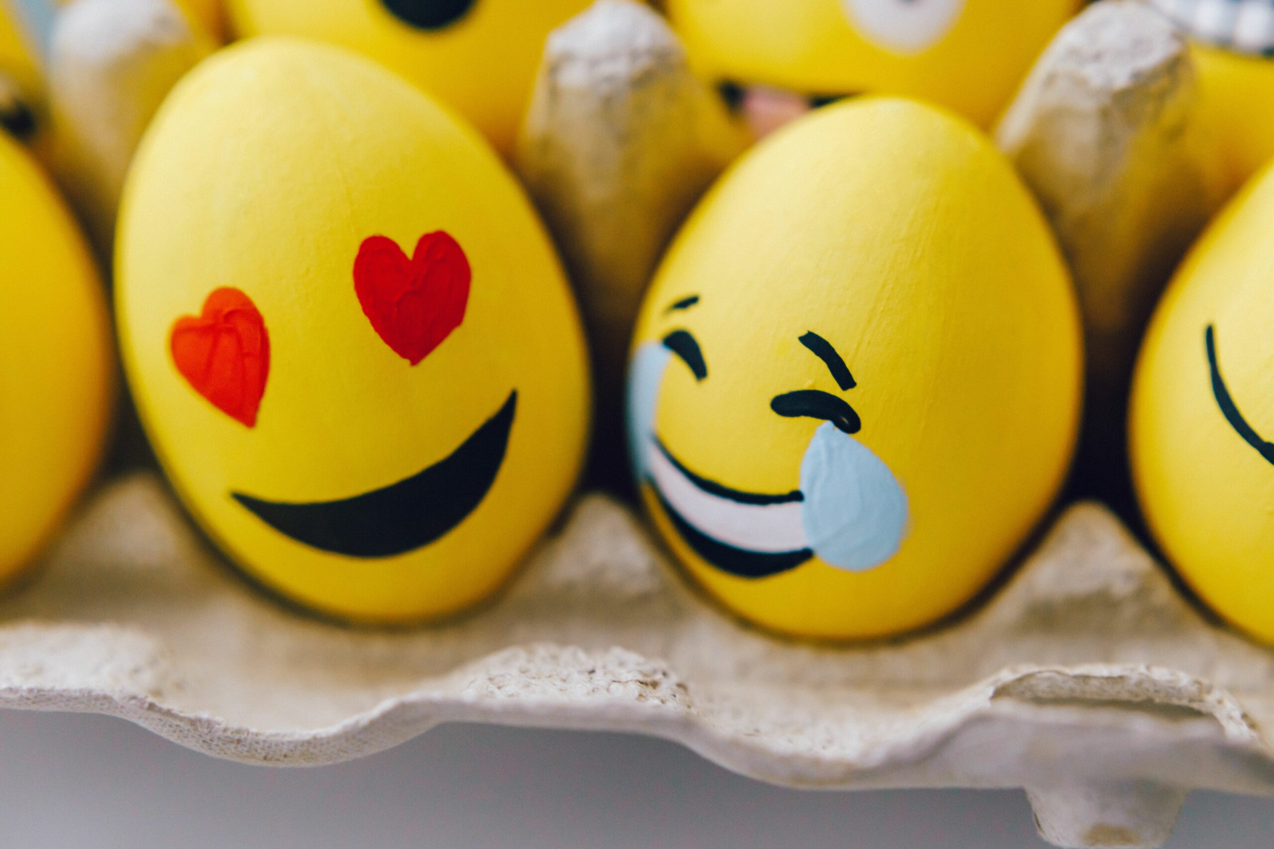 Colorful Easter eggs painted with playful emoji faces, perfect for holiday decoration inspiration.